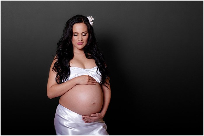 A sweet maternity portrait of the pregnant woman taken in a portable photo studio