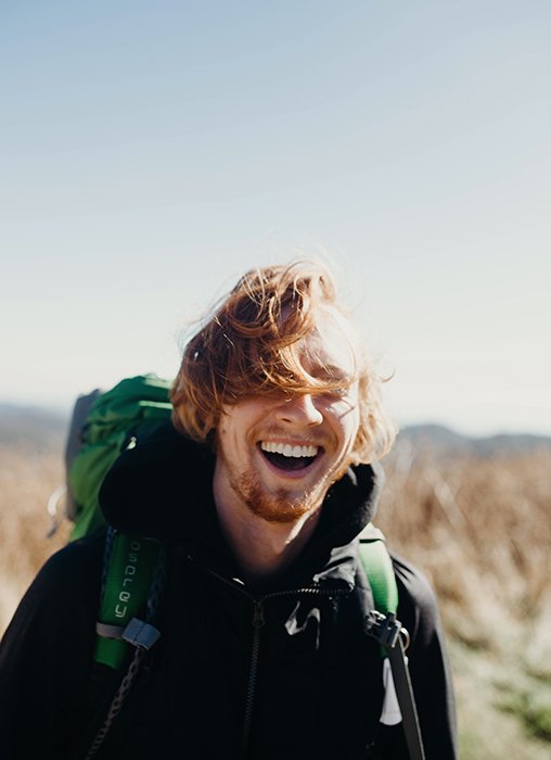Улыбающийся мужчина в походе - как улыбаться для фотографий