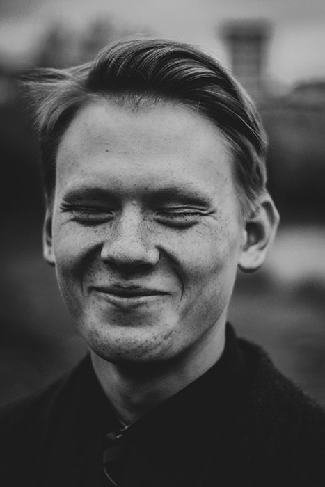Черно-белый портрет мужчины, улыбающегося естественно - как улыбаться для фотографий
