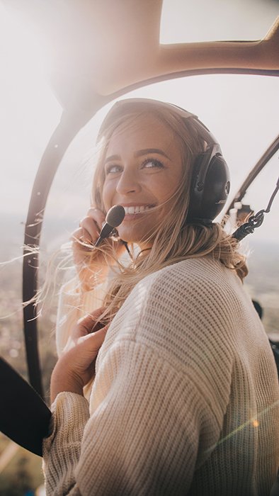 Радостная фотография блондинки в самолете, улыбающейся естественным образом