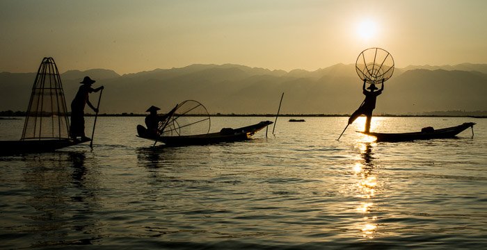 Безмятежный снимок рыбаков в озере на закате после удаления бликов на фотографиях