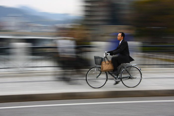 Мужчина на велосипеде в городском пейзаже с размытым фоном - правило космической фотографии