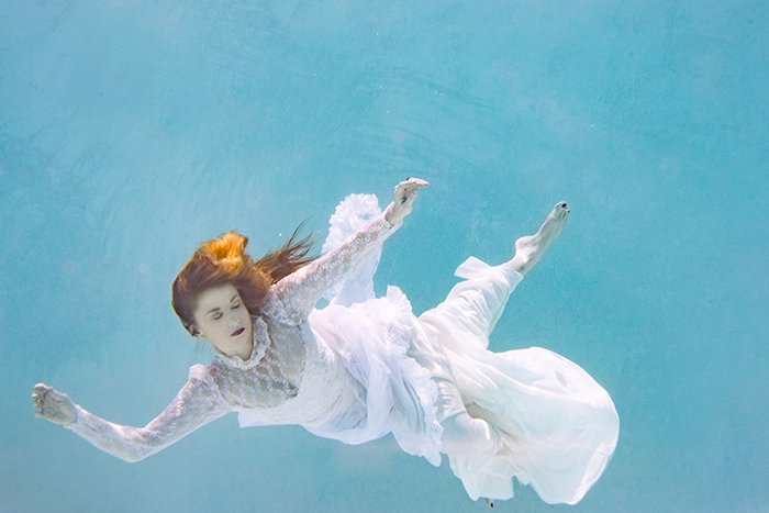 ethereal underwater portrait of the female swimmer in a long, flowy dresses look 