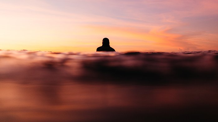 Мечтательная фотография силуэта пловца, снятая в золотой час
