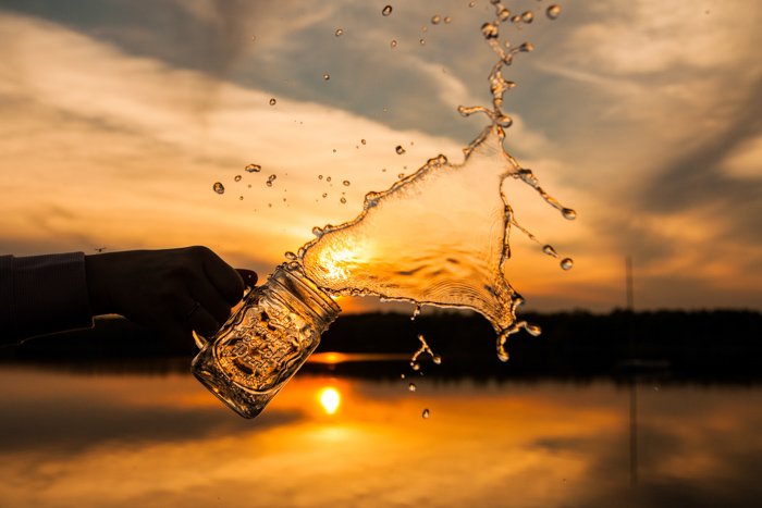 Креативная фотография брызг воды на закате на открытом воздухе