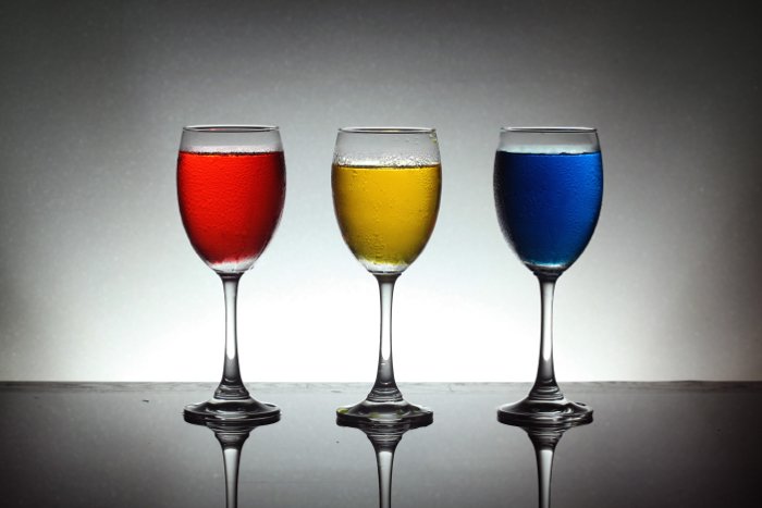 Снимок трех винных бокалов с красной, желтой и синей жидкостью внутри - лучшая накамерная вспышка