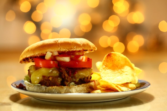 Аппетитный снимок сочного бургера с чипсами - фотосъемка со вспышкой