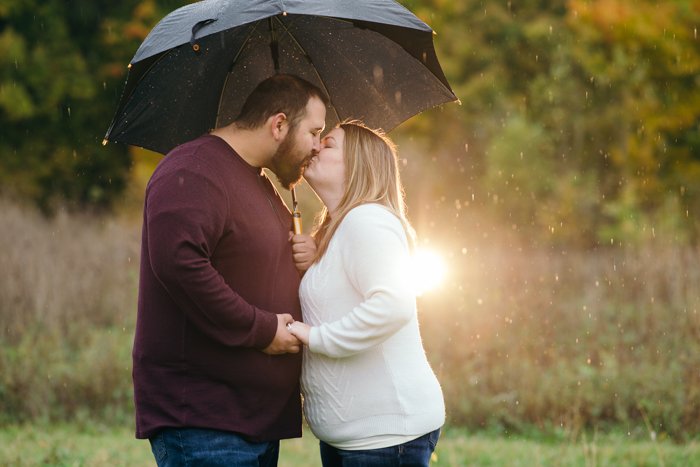 Открытый портрет пары, целующейся под зонтом