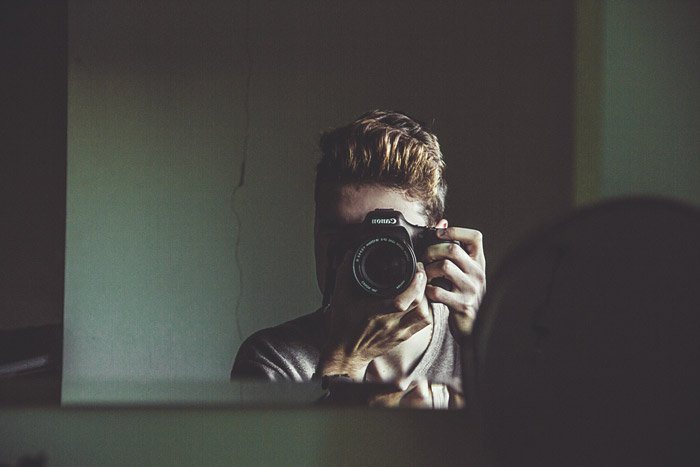 Мужчина-фотограф, говорящий о самопортрете через зеркало - темы фотографии