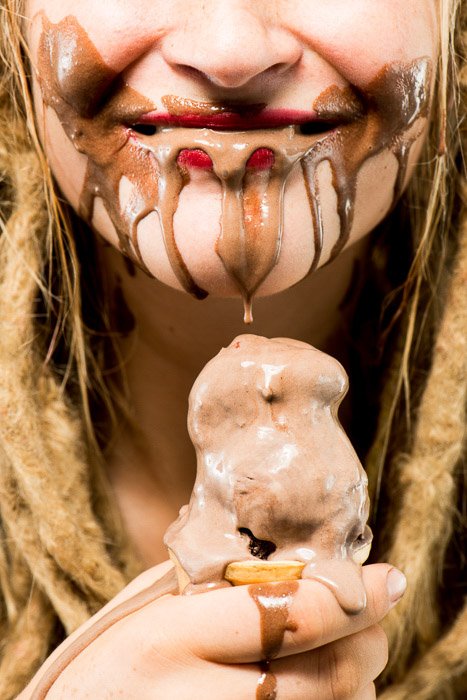 Портрет крупным планом модели, поедающей шоколадное мороженое, снятый с использованием освещения софтбокс