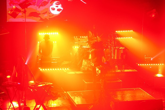 Атмосферное концертное фото сцены, освещенной электрическим красным и желтым светом