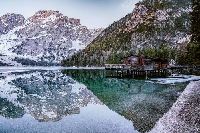 длинный домик над озером в окружении гор, использование динамического диапазона в фотографии
