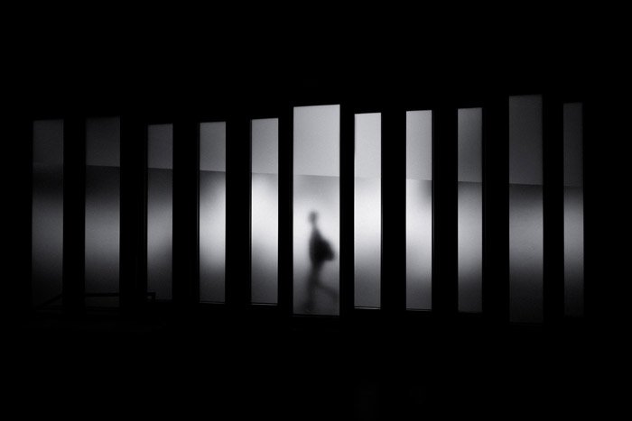 атмосферная фотография силуэта человека, идущего по линиям, демонстрирующая геометрическую фотографию