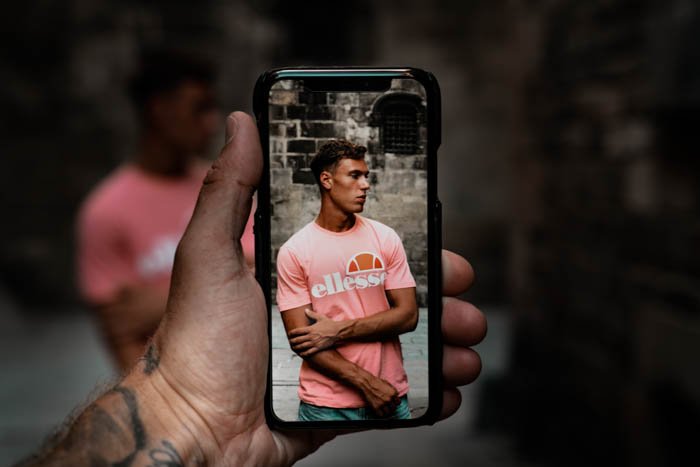 человек снимает уличный портрет смартфоном - iphone vs android камера