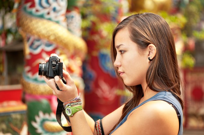 Фотография женщины, проверяющей настройки своей камеры