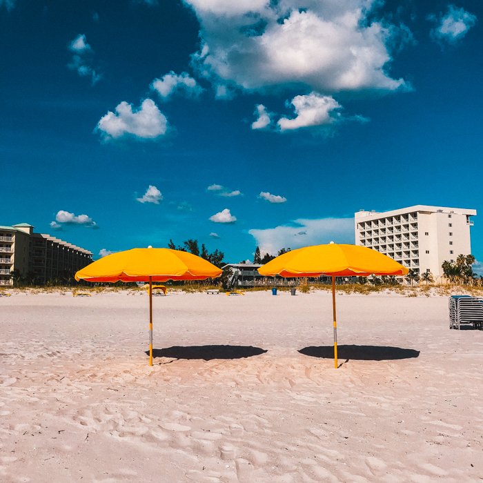 Фотография пляжной композиции с двумя оранжевыми зонтиками посередине