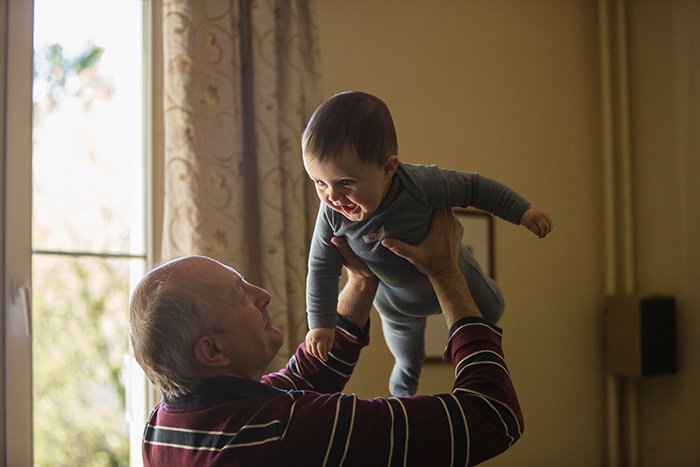 милый семейный портрет дедушки, играющего с внуком