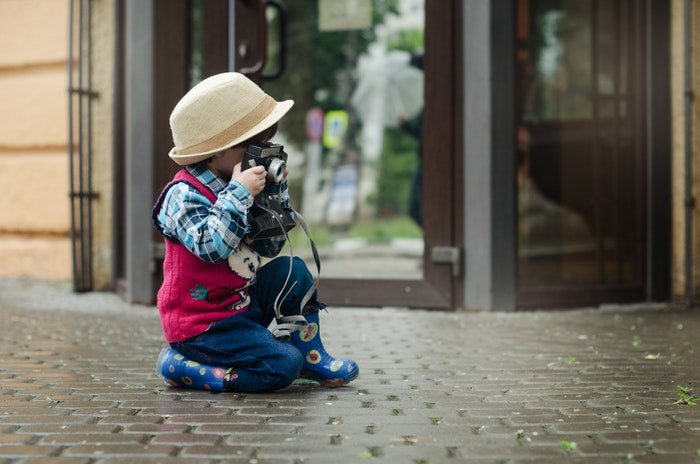 Фотография маленькой девочки, фотографирующейся на улице