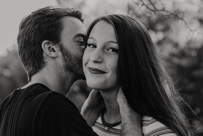 черно-белый портрет мужчины, целующего свою улыбающуюся девушку