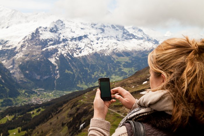 девушка снимает пейзаж на смартфон