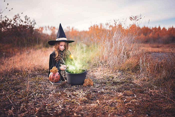 Маленькая девочка, одетая как ведьма. Ее котел был отредактирован так, чтобы казалось, что в нем варится зелье. 