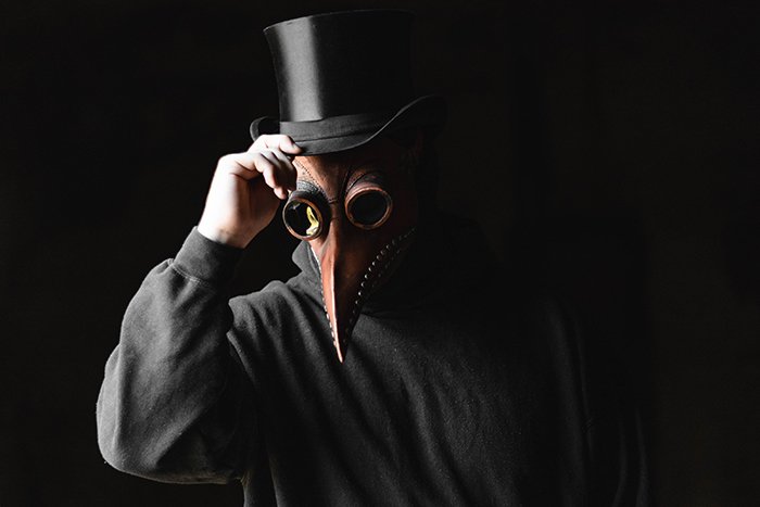 Человек в страшной маске на черном фоне
