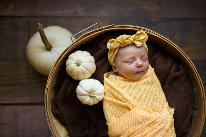 Фотография спящего ребенка с тыквами вокруг