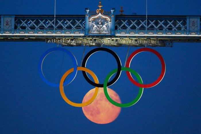 Фотография олимпийских колец и луны под ними
