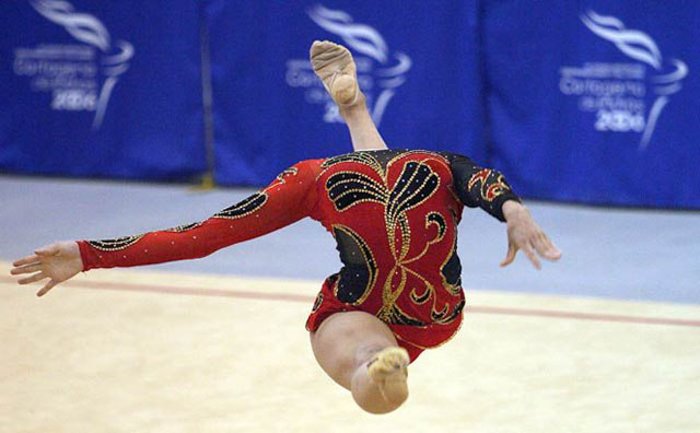 Фотография гимнастки, прыгающей в воздухе