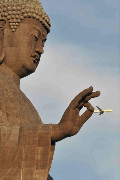 Фотография статуи Будды, выглядящей так, будто она держит самолет