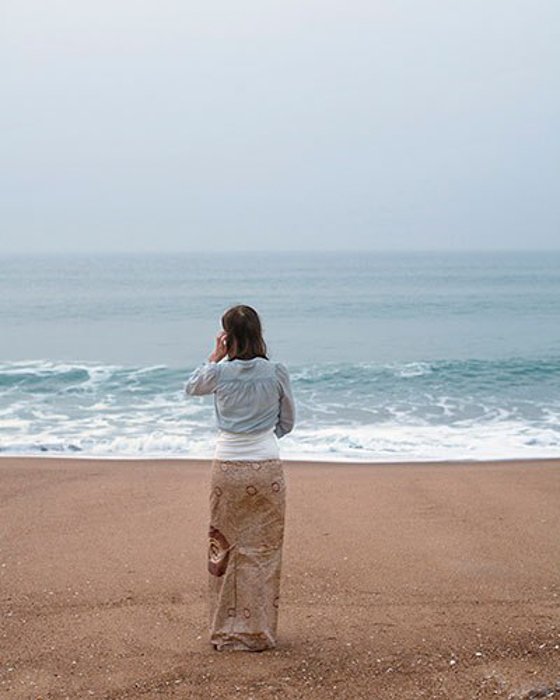 Фотография женщины, стоящей на пляже