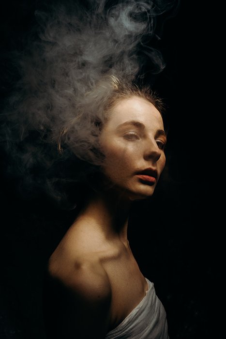 Унылый портрет девушки, дым используется для создания драматического эффекта