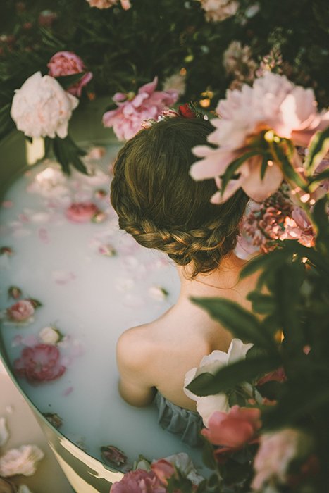 Девушка в ванне в окружении прекрасных цветов