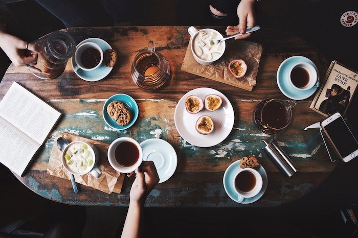 Кофейные чашки и еда, расставленные на деревянном столе