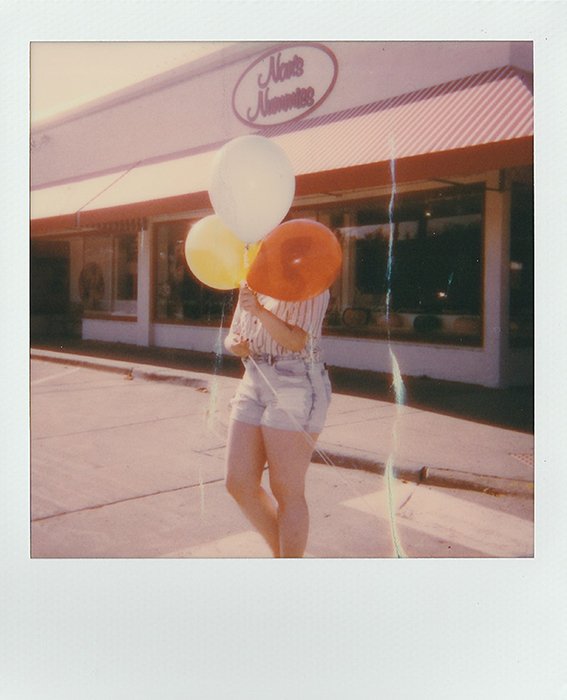 Поляроидная фотография женщины с воздушными шарами в руках