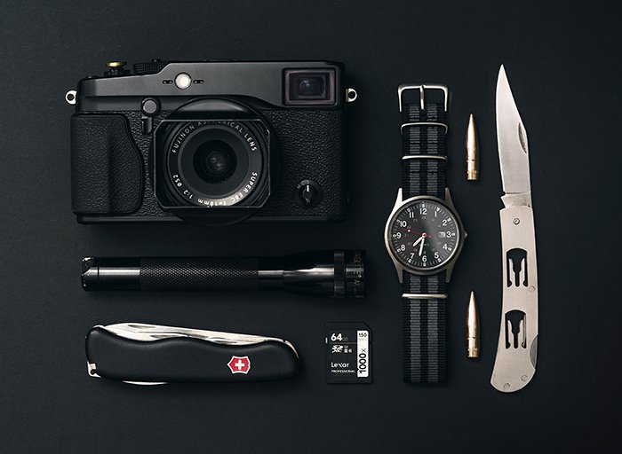 Фотография фотоаппарата, часов и карманных ножей