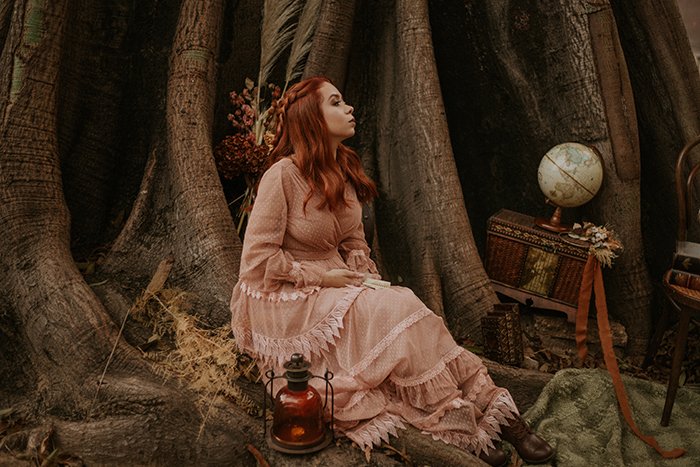 концептуальный тематический портрет женщины, сидящей в лесу
