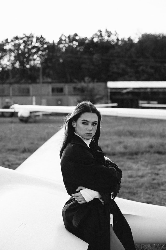 Черно-белый портрет женщины-модели, сидящей в самолете