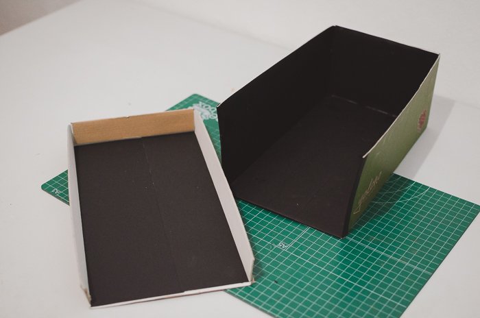 Приклеивание черной бумаги к коробке из-под обуви для создания DIY-проектора