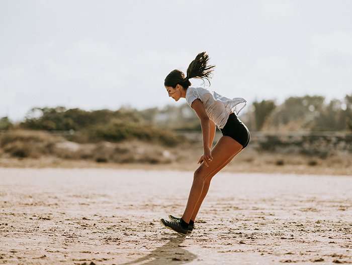 Женщина тренируется на пляже