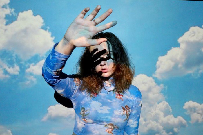 Портрет женщины-модели с проецируемой на нее фотографией облаков