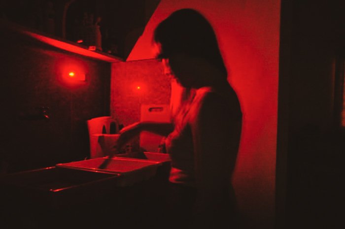 Девушка проявляет пленку в фотолаборатории DIY