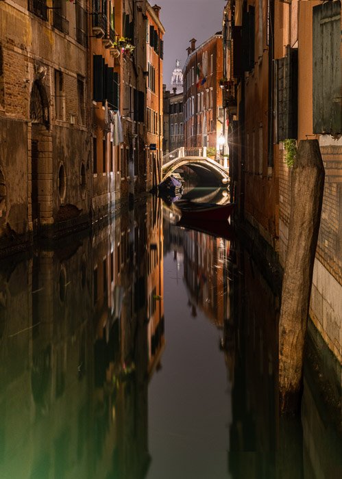 Более крупный план венецианского канала ночью.