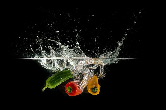 высокоскоростной снимок овощей, брызгающих в воду