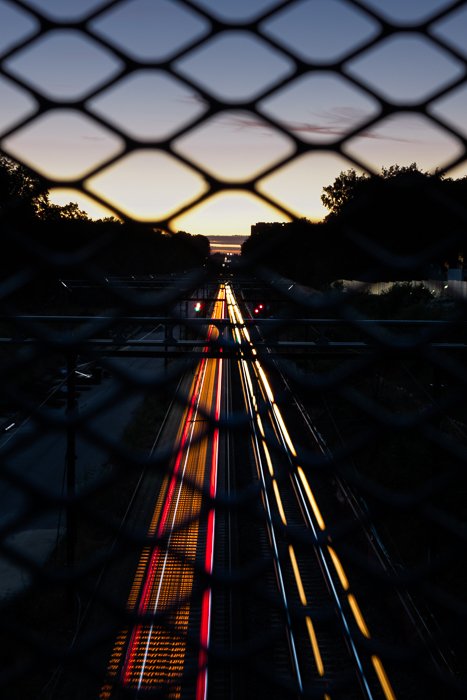 Фотография с моста, показывающая световые следы проезжающих внизу машин