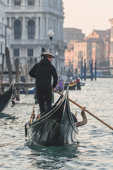 Фотография мужчины на гондоле в Венеции, снятая с использованием малой глубины резкости