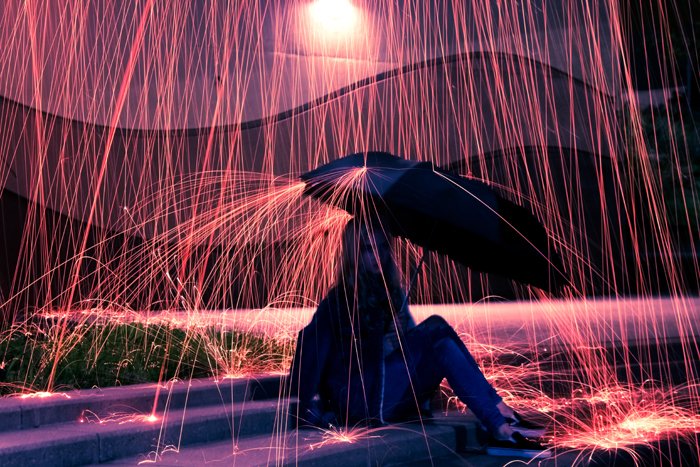 девушка, держащая зонт под дождем эффект, созданный фотографией стальной шерсти