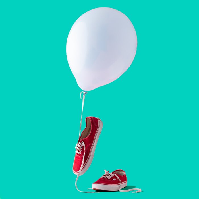 фото красных кроссовок с белым воздушным шаром и бирюзовым фоном