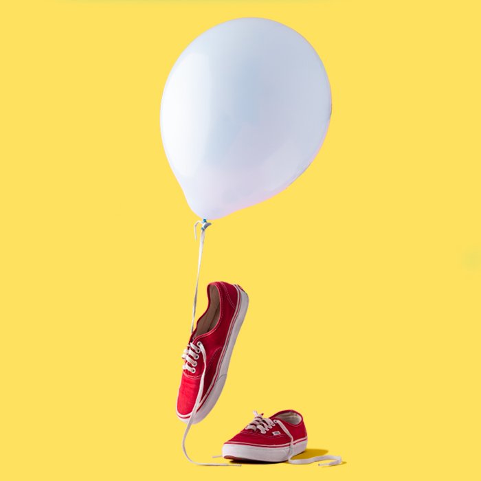 фото красных кроссовок с белым шаром и желтым фоном