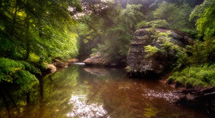 Фотография небольшого озера в лесу с эффектом ортона
